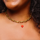 Woman wearing a necklace stack including a gold, waterproof, chunky link choker