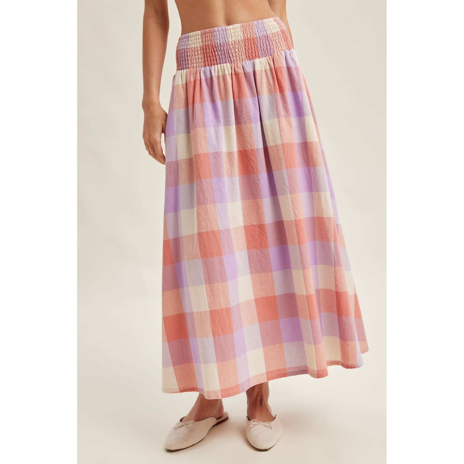 Person wearing a plaid skirt on a plain background