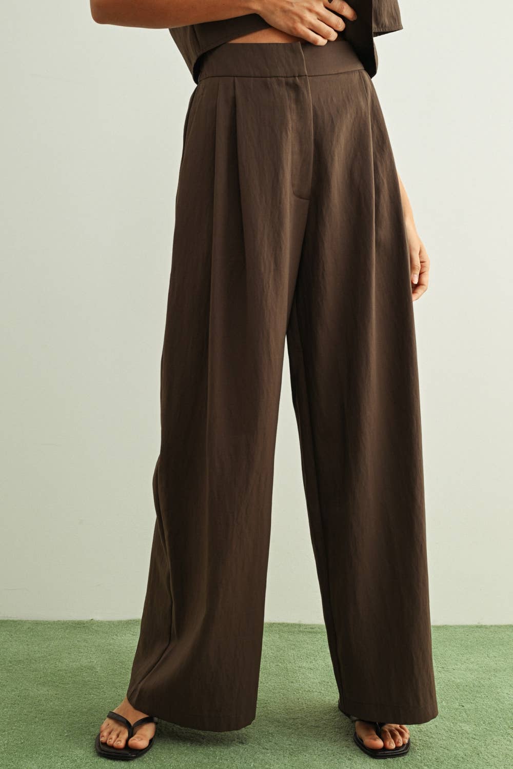 Brown wide-leg pants worn by a person on a plain background