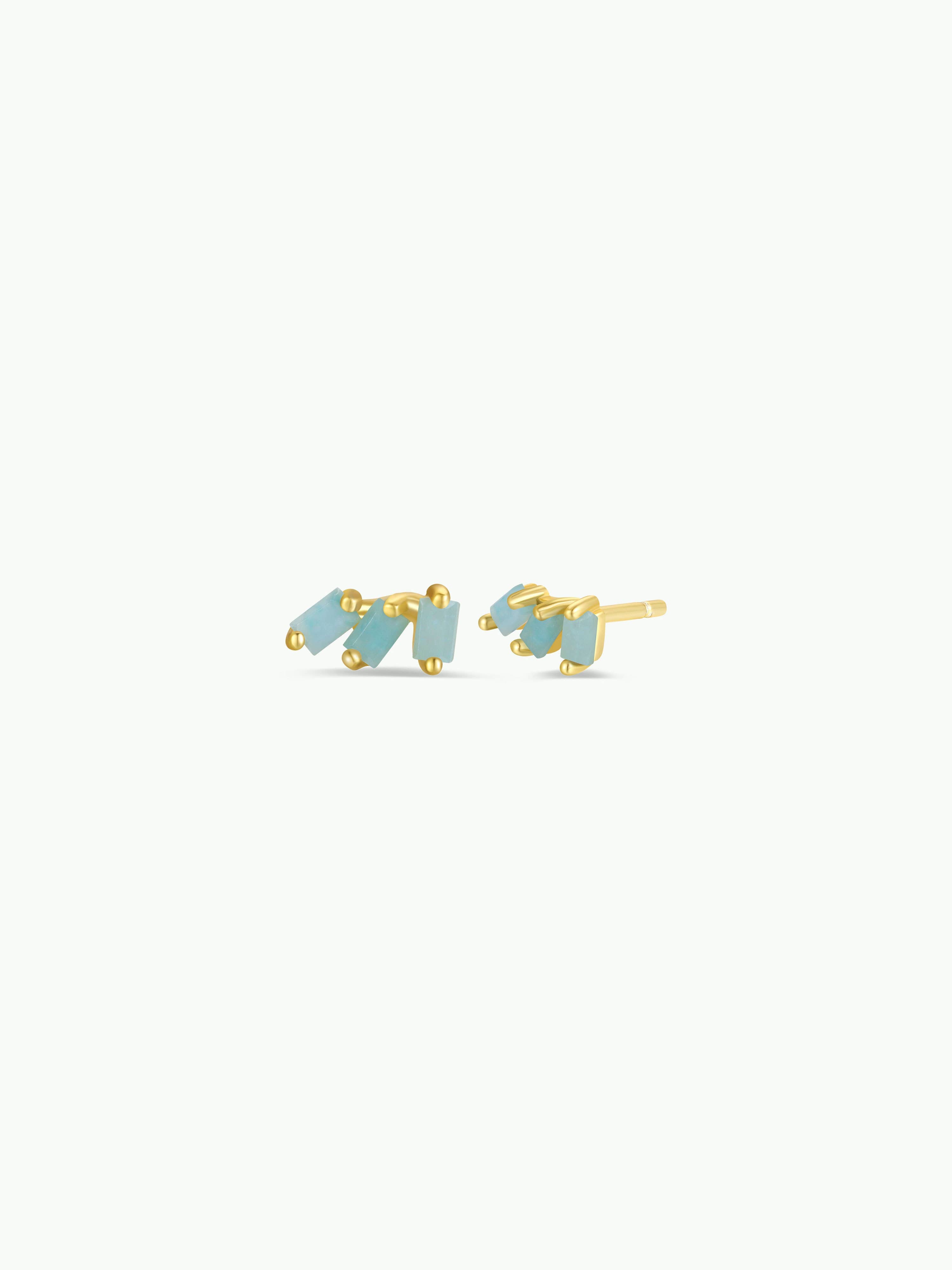 Gold earrings with blue stones on a white background