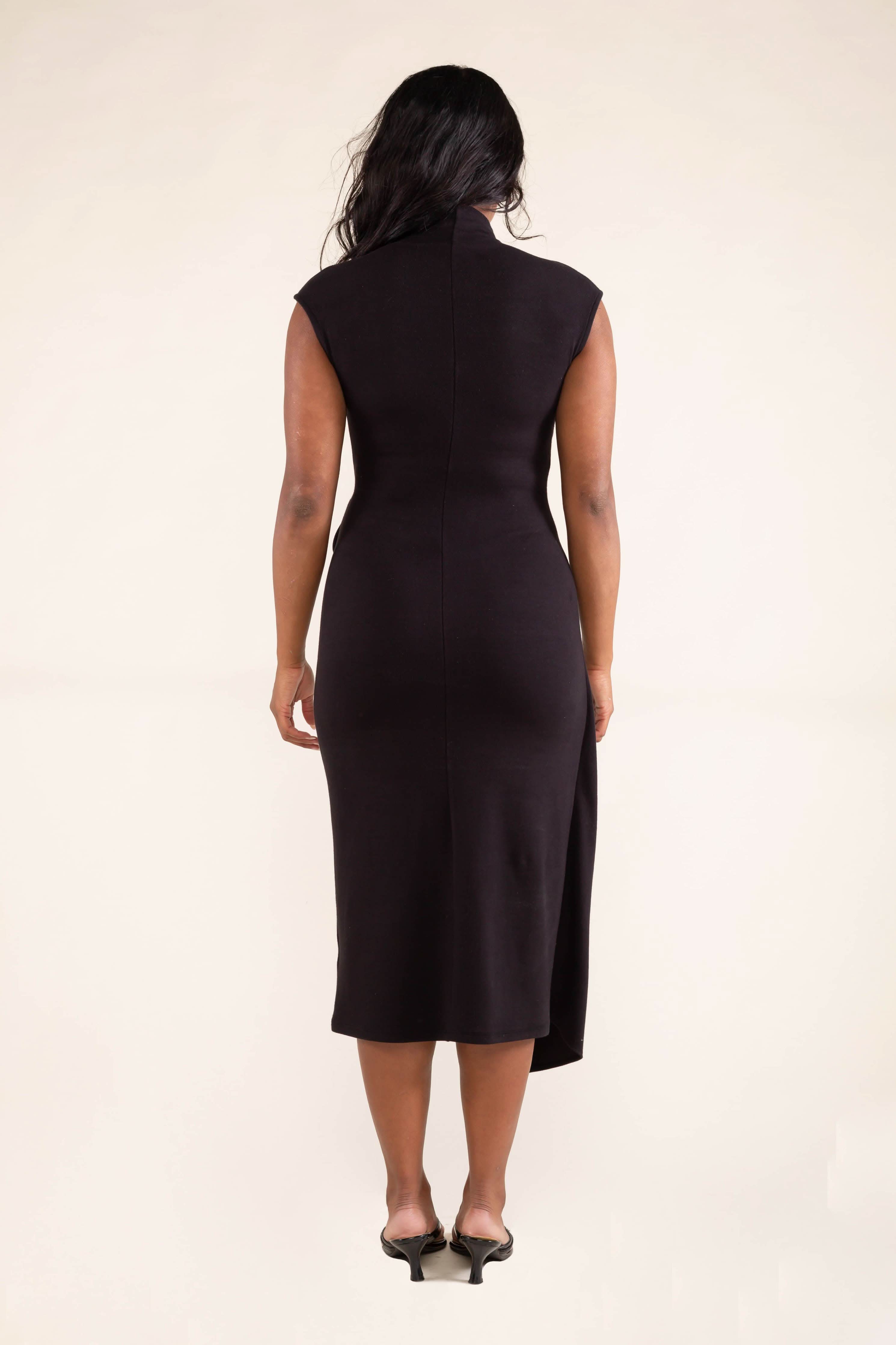 Woman wearing a black sleeveless dress on a beige background