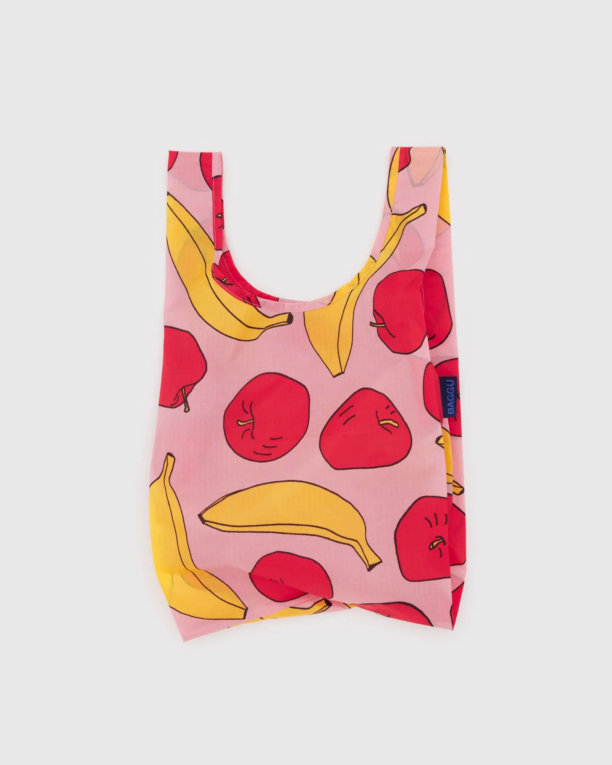 White background and BAGGU light pink reuse-able bag with apples and banana details 