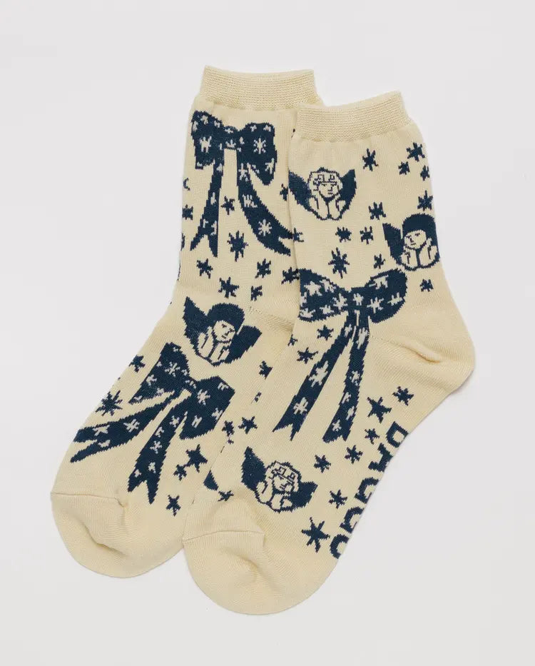 Beige socks with blue angel and bow designs on a white background