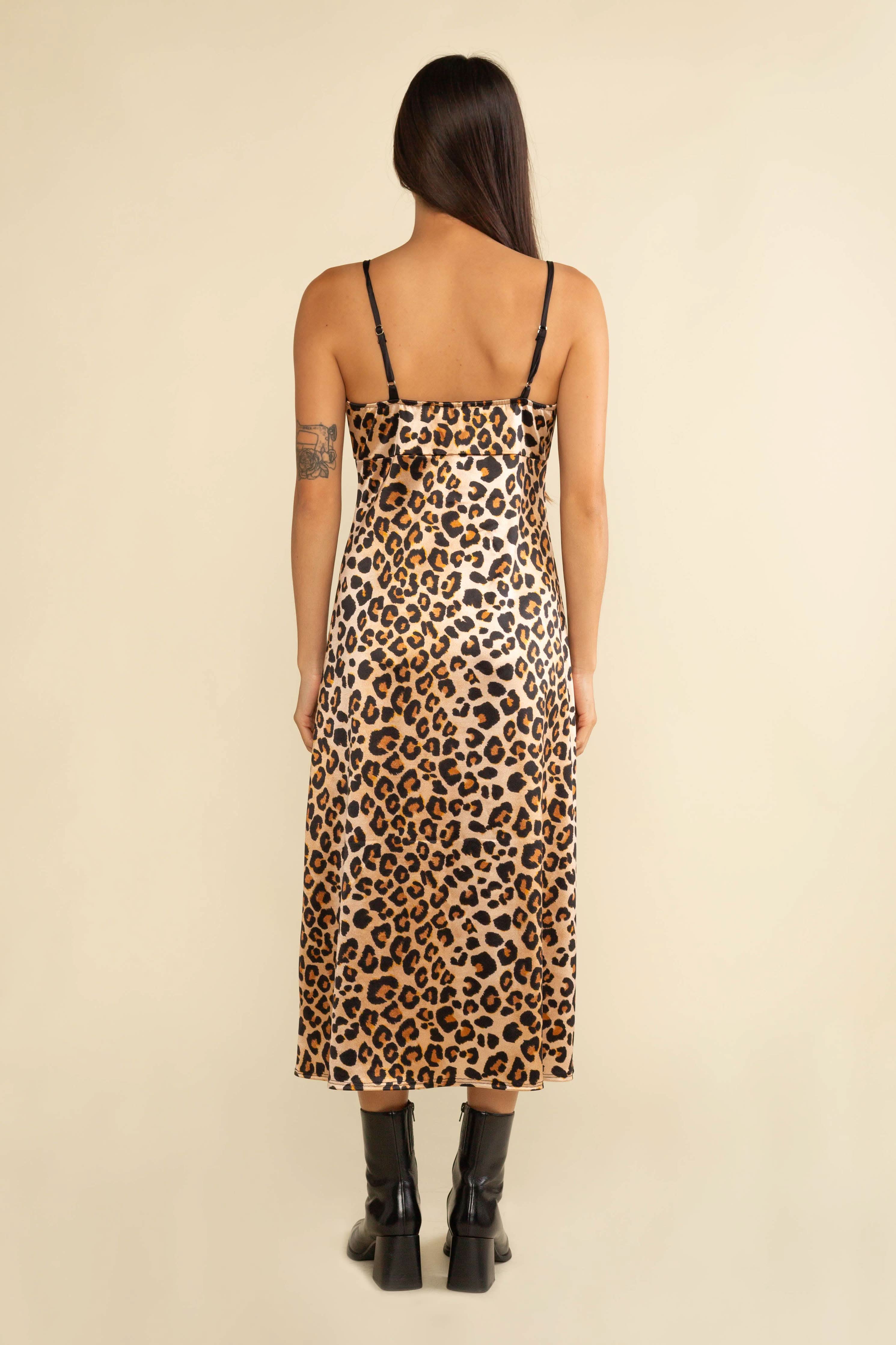 Person wearing a leopard print dress on a beige background