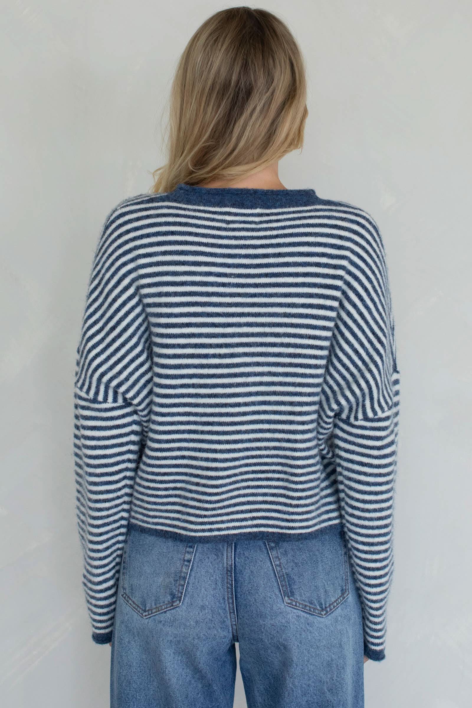 Person wearing a blue and white striped sweater back side