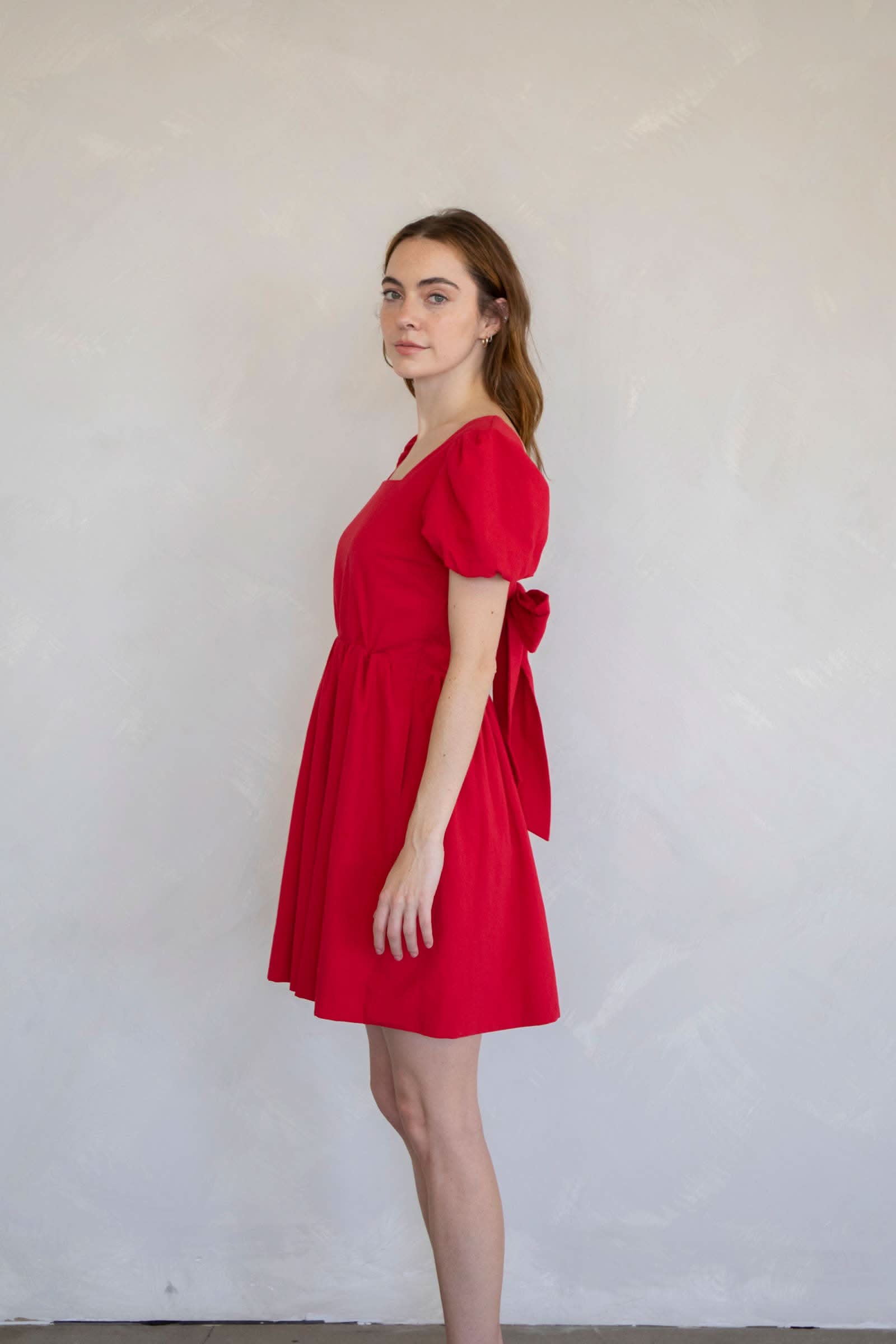 Woman wearing a red dress side face view dress