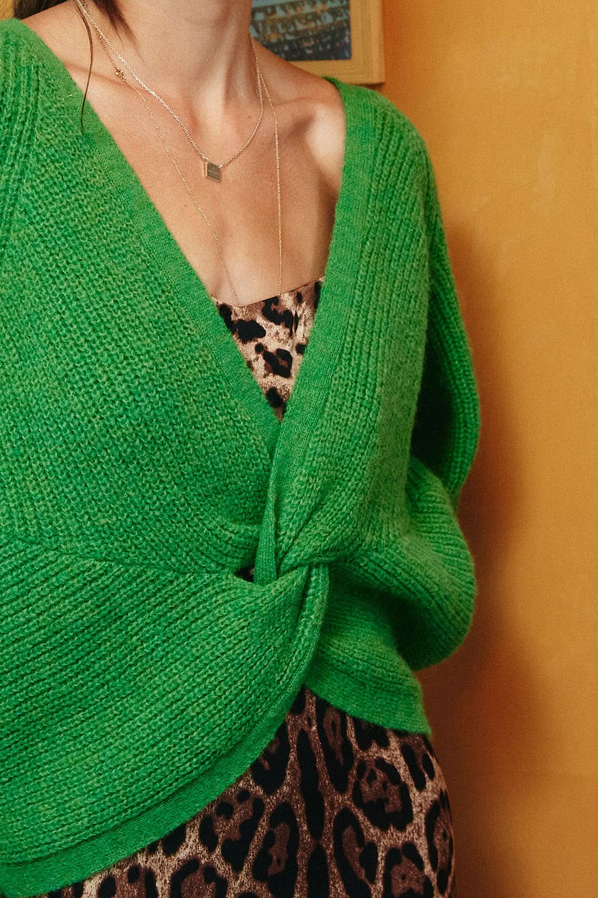 Green knitted cardigan over a leopard print dress 